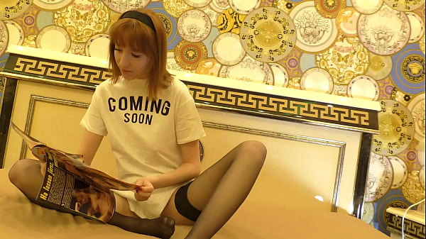 Heiße, enge, dünne Rothaarige ohne BH und ohne Höschen auf dem Bett langweilt sich und wird in schwarzen Strümpfen ignoriert